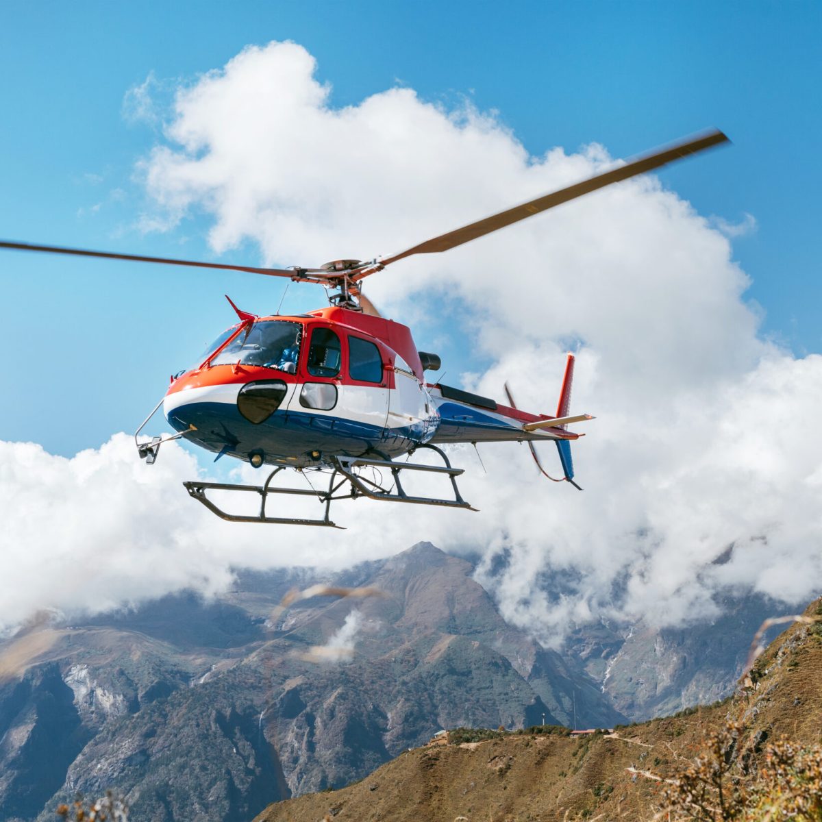 a helicopter flying over a mountain